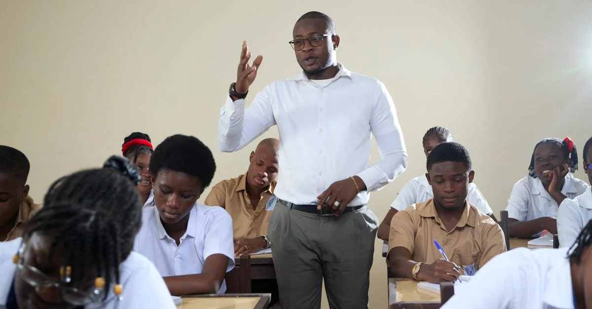 Un enseignant interagit avec des élèves du secondaire dans une salle de classe.