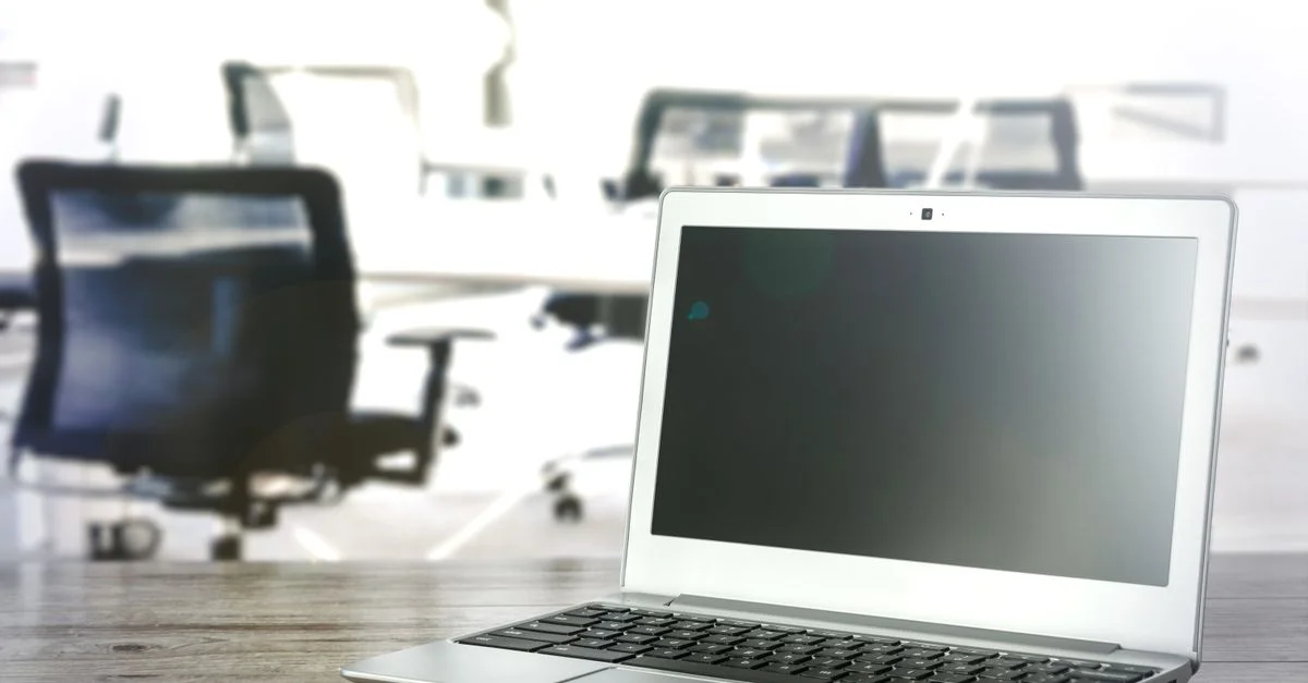 Un ordinateur portable élégant sur un bureau dans un environnement de bureau moderne et lumineux.